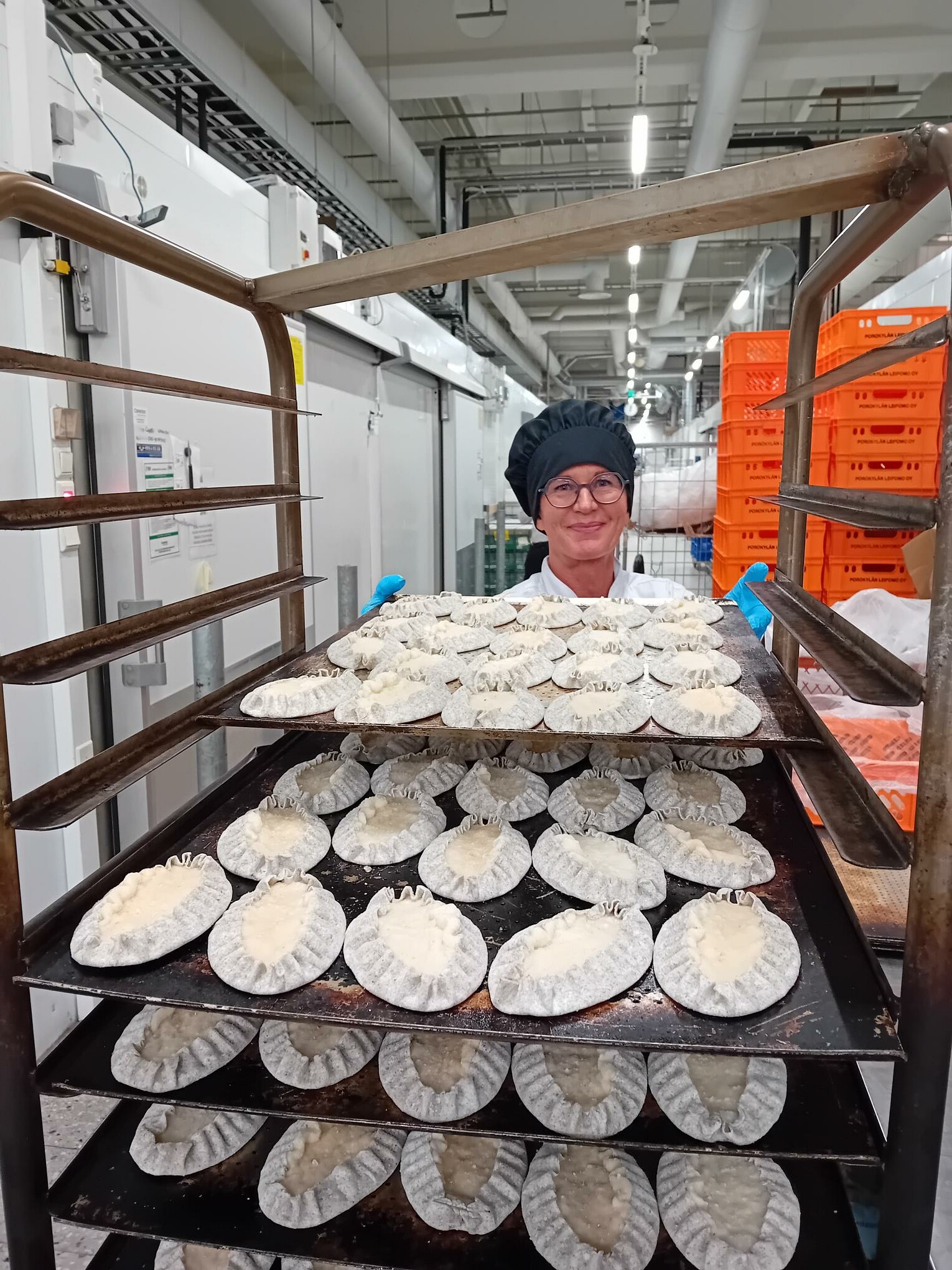 Myymäläleipuri Kirsi Ikonen pellittää Nurmeksessa esivalmistettuja karjalanpiirakoita paistettavaksi.